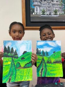 two kids holding artwork